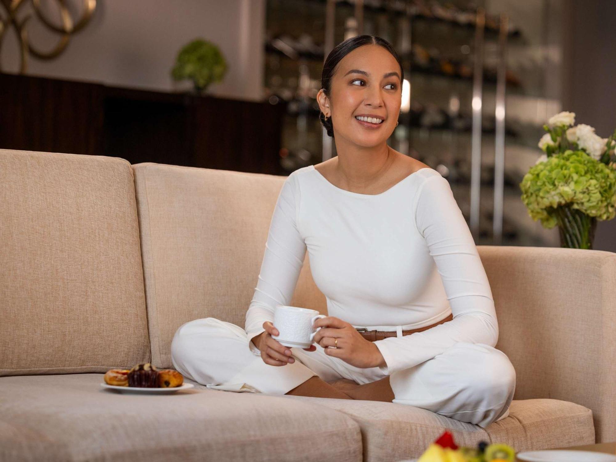 Fairmont Makati Otel Makati City Dış mekan fotoğraf A woman sitting on a sofa